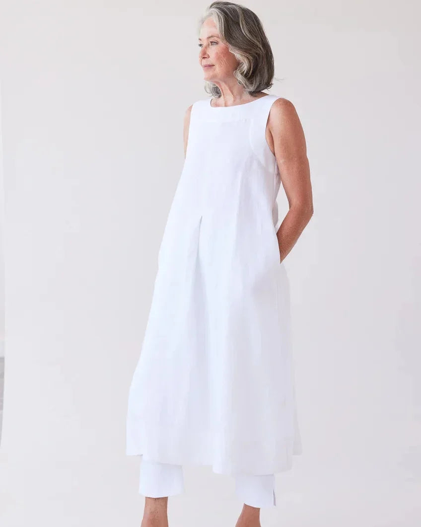 Eva’s Sunday Paloma Sleeveless Dress in White, styled over white cropped trousers