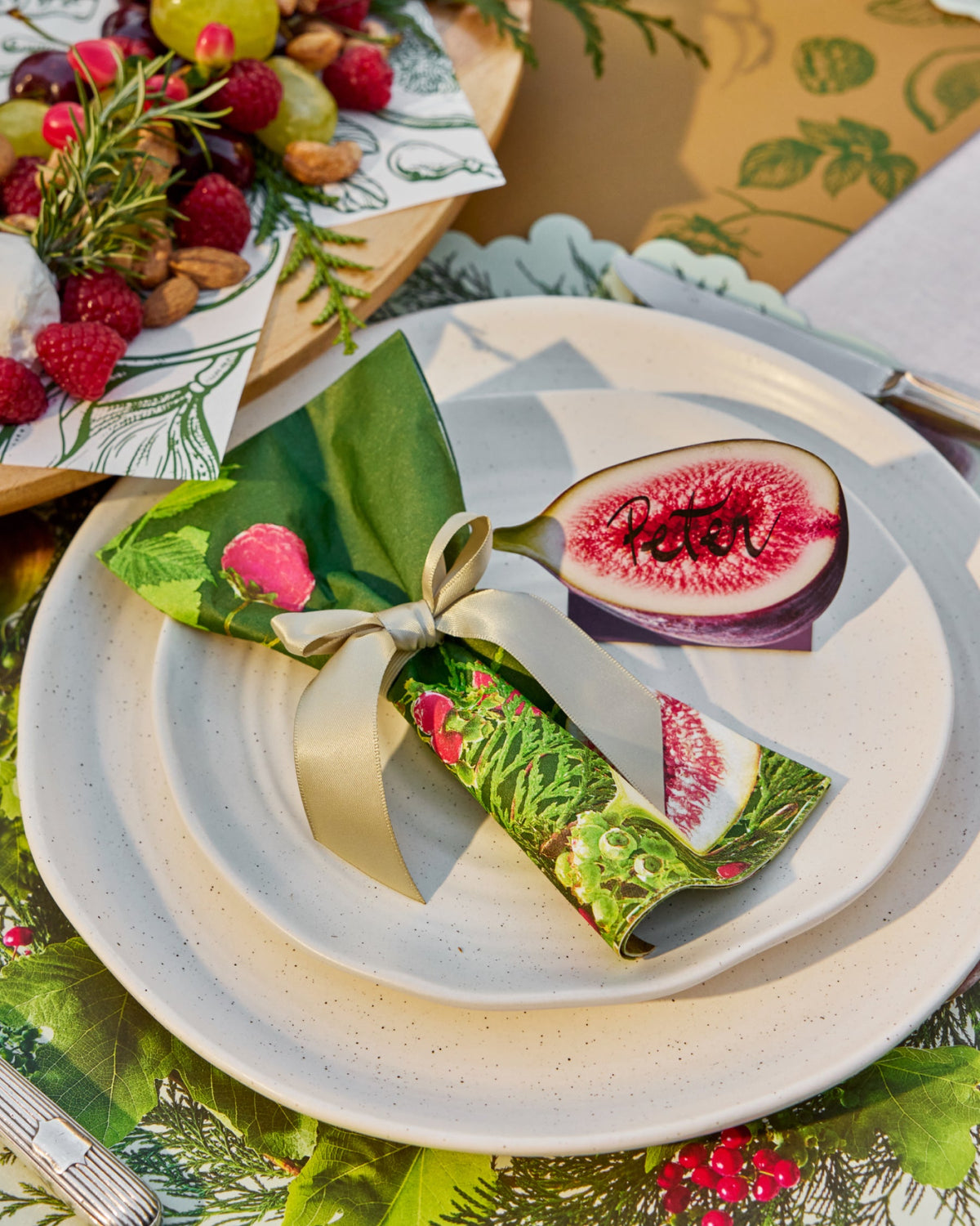 Festive paper dinner napkins with figs, green leaves and pink floral details.