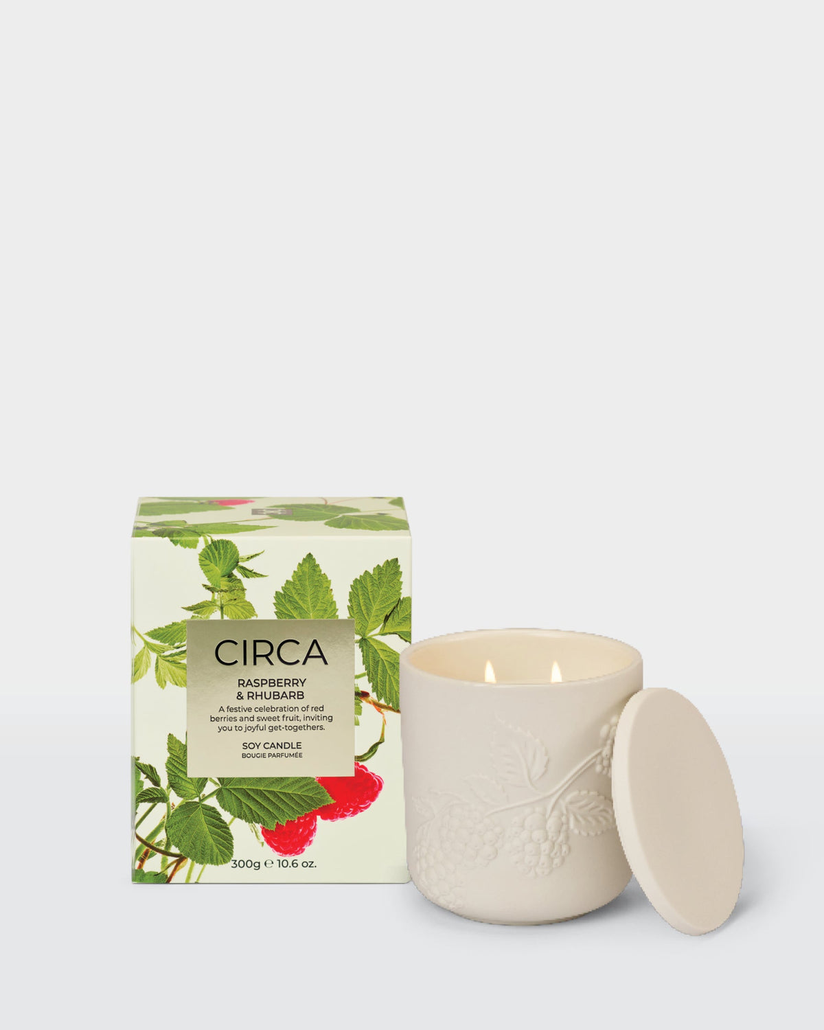 Raspberry & Rhubarb 300g Soy Candle with embossed ceramic vessel and lid beside its front-facing raspberry-print box.